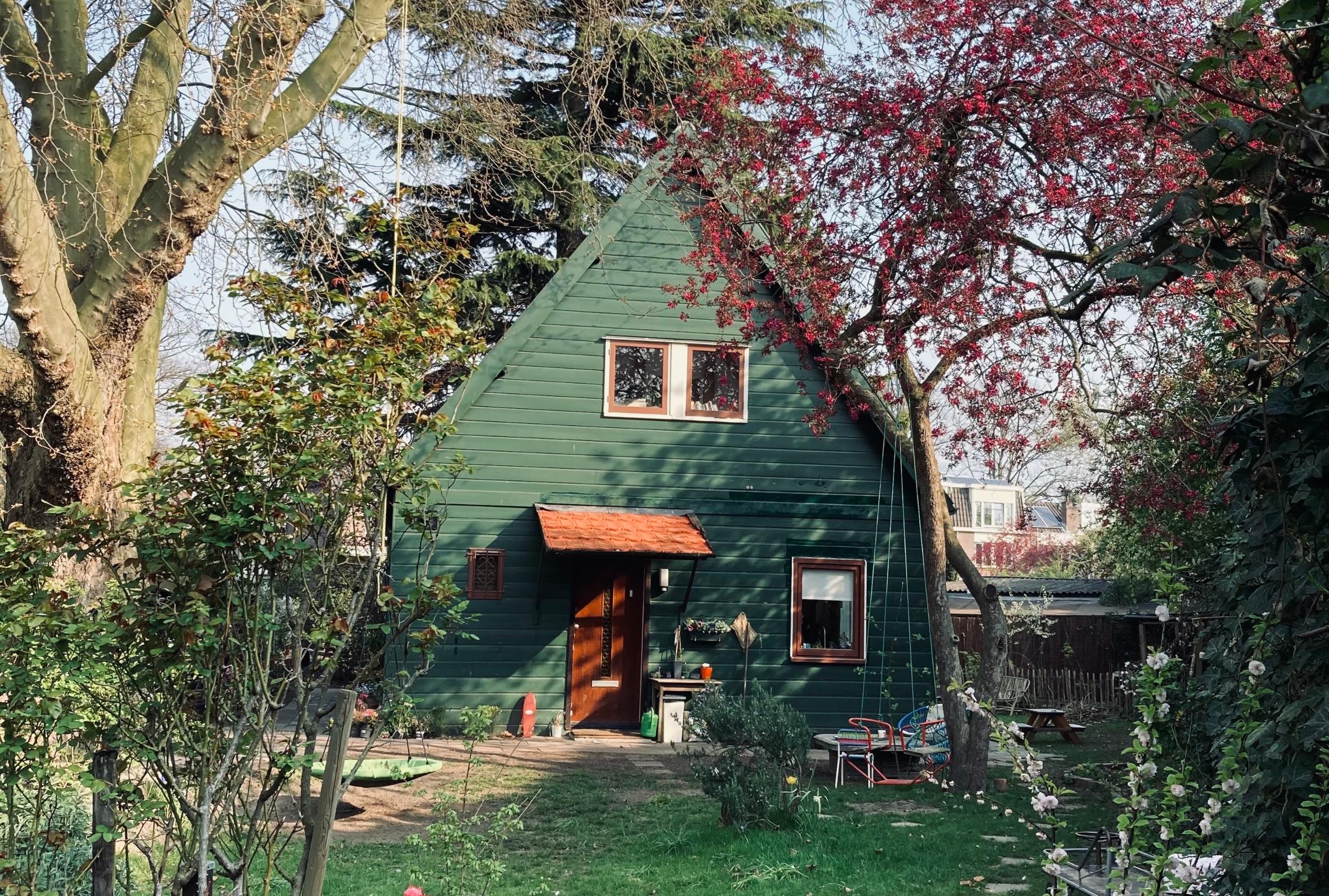 Het houten huis aan de Schutstraat, verborgen in het groen